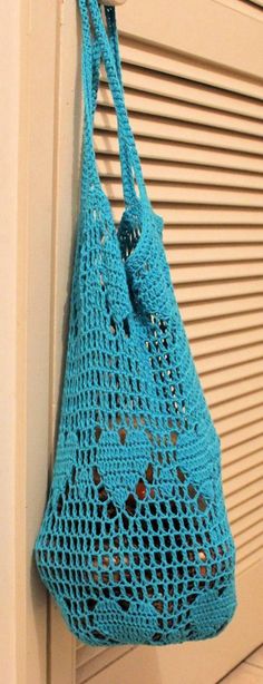 a blue crocheted bag hanging on the side of a door