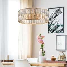 a dining room table with flowers and pictures on the wall