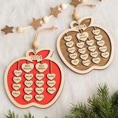 two wooden christmas ornaments with hearts and an apple on the top one is for each family member