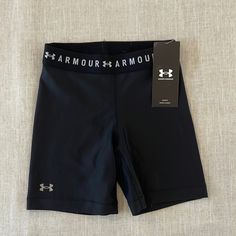 the under armour shorts are black and have white lettering on them, along with a tag