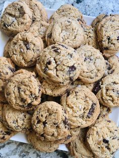 chocolate chip cookies are on a white plate