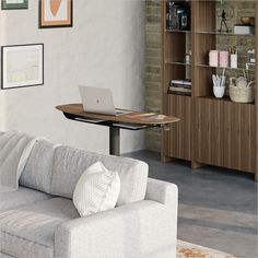 a laptop computer sitting on top of a wooden table next to a couch in a living room