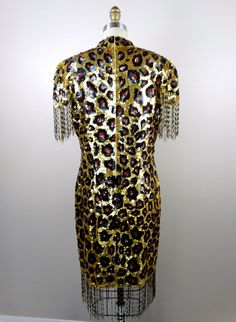 "Here's another fun and fabulous vintage dress fully embellished with sequins and beading featuring a leopard print design. It's in excellent condition! Bust - 38/40\" Waist - 32/34\" Hips - 40/42\" Length - 37\" + 5\" fringe beading Tag Size - XL (please refer to measurements) This dress comes from a pet-free and smoke-free home. If you would like more info or have any questions, please don't hesitate to ask!" Glamorous Fitted Sequin Dress With Beaded Fringe, Fitted Sequin Dress With Beaded Fringe, Hand Embellished Fitted Sequin Dress, Fitted Hand Embellished Sequin Dress, Fitted Sequin Evening Dress With Beaded Fringe, Embellished Dress For Costume Party During Party Season, Summer Sequin Embellished Dress For Costume Party, Fitted Sequin Dress With Embellished Fringe For Party Season, Embellished Sequin Dress For Costume Party And Holiday