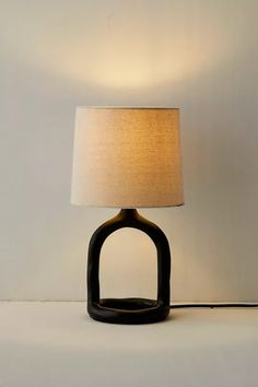 a lamp that is sitting on top of a white table next to a black object