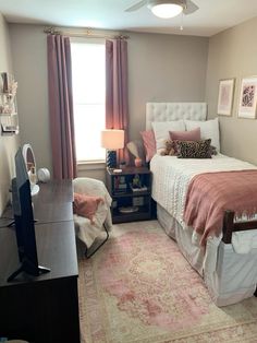 a bed room with a neatly made bed next to a window and a desk in front of it