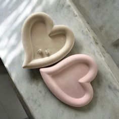 two heart shaped molds sitting on top of a marble counter next to each other