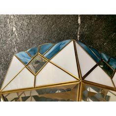 a close up of a glass and metal object on a wall with black marble behind it