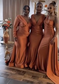 three women standing next to each other in dresses