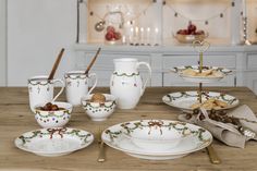 a wooden table topped with dishes and cups