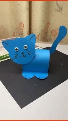 a blue paper cat sitting on top of a table