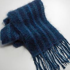 a blue and black scarf laying on top of a white table