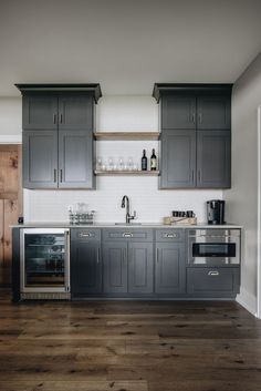 a kitchen with gray cabinets and stainless steel appliance on the countertop, along with an oven