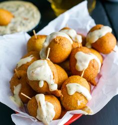 small appetizers with toothpicks and sauce in a red bowl on a table