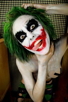 a woman with green hair and makeup is posing for the camera while dressed as a joker