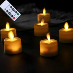 five lit candles with remote control on table