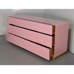 a pink dresser with two drawers in the middle