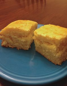 two pieces of cornbread on a blue plate with a wooden table in the background