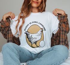 ✺ FLUENT IN FOWL LANGUAGE - CHICKEN GRAPHIC TEE ✺ * Q U I C K F A C T S * This design is a unique, one-of-a-kind awesome illustration that has been created in house. The design has a distressed effect, which gives a tee a worn-out look. This effect is intentional. ✺ 100% Cotton (fiber content may vary for different colors) ✺ Classic fit ✺ Sizing is unisex, so it fits both women and men (true to size) Please note that colours may appear different on different digital screens and may not be a true Chicken Graphic, Cottage Core Shirt, Fowl Language, Chicken Mama, Chicken Shirt, Chicken Gifts, Oversized T Shirt Dress, Chicken Shirts, Funny Chicken