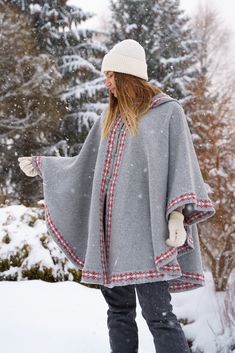 The poncho comes in a longer, more flattering length, and has a loose, oversized shape. Features a woolen hood and an intricate minimalist ornament. We've added special details like metal buckles for a stylish, feminine touch. - 100% wool - Loose, oversized shape - Minimalist ornament SKU CODE:  VP-009 Winter Poncho Cape For Cold Weather, Hooded Wool Cape For Winter, Cozy Winter Cape Poncho, Winter Wool Poncho For Cold Weather, Wool Cape For Winter Weather, Wool Cape For Winter Cold Weather, Wool Winter Cape For Cold Weather, Winter Wool Cape For Cold Weather, Women's Ponchos & Wraps