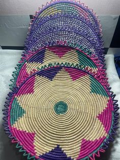 three baskets sitting on top of a table next to each other in different colors and sizes