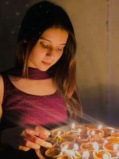 a woman holding a tray with lit candles