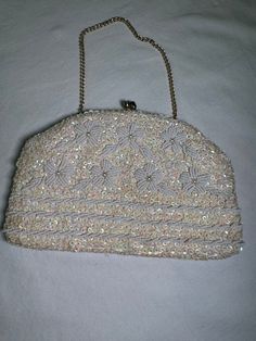 Details: 1950's vintage evening bag kisslock closure Richere Brand gold link chain strap floral beading with sequins Lined interior pocket ivory/white great bridal accessory! Measurement (in inches): Bag body length: 5 chain handle: 12 Bag body width (at widest) : 8 Condition: great vintage condition- no notable damage to bead work, light markings on interior lining Vintage Embellished Clutch Evening Bag, Vintage Embellished Clutch For Party, Vintage Beaded Clutch For Events, Vintage Evening Bags With Sequins, Vintage Evening Bag With Sequins, Vintage Formal Evening Bag With Sequins, Vintage Sequin Party Bag, Vintage Sequined Clutch Evening Bag, Vintage Sequined Evening Bag For Events