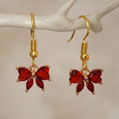 Make a statement with these pretty red bow drop earrings for women. These cool quirky gold plated and rhinestones bow earrings are a great way to add a nice touch to your outfit. The charm on these bow dangle earrings measures at 1.2cm x 1cm and is attached to a gold plated hook. Please feel free to get in touch with us at Funky Earrings UK if you have any questions. We also have a wide range of other cute and unusual earrings in our shop. Elegant Red Jewelry With Bow, Valentine's Day Jewelry With Red Bow, Valentine's Day Party Jewelry With Red Bow, Earrings Cool, Red Flower Earrings, Unusual Earrings, Funky Earrings, Gold And Red, Bow Jewelry