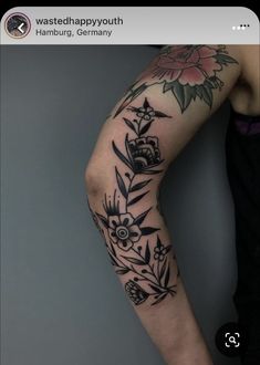 a woman's arm with flowers and leaves on it