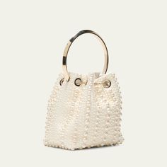 Jimmy Choo "Bon Bon" bucket bag in allover pearly satin viscose, brass, and ABS Flat metal top handle  Drawstring closure  Approx. 5.9"h x 5.5"W x 3.7"D Item Weight (Lbs.): 1.0 Made in Italy Luxury Handheld Bucket Bag For Evening, Luxury Handheld Bucket Bag For Formal Occasions, Luxury Formal Handheld Bucket Bag, Evening Handheld Bucket Bag With Gold-tone Hardware, Party Evening Bag With Detachable Handle, Bucket Shape, Party Bucket Evening Bag With Detachable Handle, Luxury Shoulder Bag With Pearl Handle For Shopping, White Bucket Bag For Evening, Luxury White Evening Bucket Bag