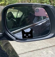 a side view mirror with a black cat sticker on it