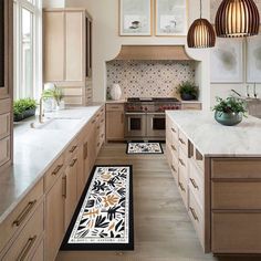 a kitchen with an area rug on the floor and two hanging lights over the stove