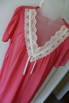 Vintage pink nightgown/negligee with lace trim at the v-neck and short sleeves.  Clean, undamaged, no stains, like new. Made in USA by Vanity Fair. Tag size is medium. Measures approx. 19 inches laying flat from arm-pit to arm-pit (38 inches total). Gown is 38 inches from shoulder to hem.  100 % nylon; machine washable.  Fun shower, bridal, birthday, or Valentine's Day gift for the vintage lover. Measured laying flat so the actual fit will be a bit smaller. Measure a similar garment that fits yo Feminine V-neck Nightgown With Lace Trim, Pink V-neck Nightgown With Lace Trim, V-neck Lace Trim Sleepwear For Wedding Night, V-neck Wedding Night Sleepwear With Lace Trim, Feminine Lace Trim V-neck Nightgown, Pink V-neck Sleepwear For Wedding Night, Feminine Short Sleeve Sleepwear With Lace Trim, Feminine Lace Trim Short Sleeve Sleepwear, Pink Lace Trim Nightgown For Sleepover