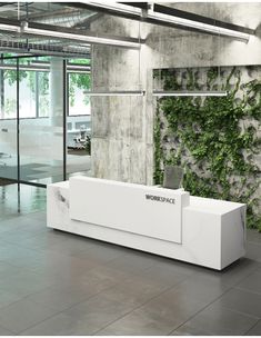 an office lobby with a plant wall on the wall and a white bench in front of it