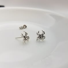 Sterling  Silver Spider Earrings These Halloween themed sterling silver spider stud earrings perfect for adding a hint of Halloween spirit to your look, the frightful yet delightful design features detailed miniature spider crafted with the quality sterling  silver, ensuring that they will last you through many Spookytacular seasons! Size: approximately 8mm x 10mm Finish: platinum plated on top of the sterling silver. Post size: 22 gauge, 11mm long Sold as a PAIR Comes with gift box Earring back Spider Stud Earrings, Spooky Silver Pierced Earrings, Spooky Silver Nickel-free Earrings, Spooky Nickel-free Silver Earrings, Gothic Sterling Silver Hypoallergenic Earrings, Gothic Hypoallergenic Sterling Silver Earrings, Spooky Silver Dangle Earrings, Spooky Silver Earrings For Gift, Silver Ear Wire Earrings For Halloween