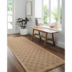 a wooden table sitting on top of a hard wood floor next to a white vase