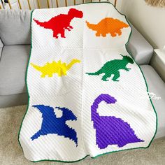 a crocheted blanket with dinosaurs on it