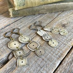 several pieces of metal sitting on top of a wooden table next to an old book