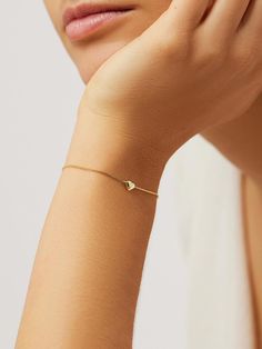 Delicate, dainty, and dipped in 14k gold, this heart bracelet is destined to become a staple in your everyday stack. Featuring a heart-shaped pendant and shiny polished finish, this bracelet is one you’ll fall in love with over and over again. Pair this heart bracelet with our Lo Hoops for a match made in minimalist heaven. • Dipped in tarnish-proof 14k gold • Heart-shaped pendant • Shiny polished finish Gold Heart Bracelet, Elegant Bracelet, Gorgeous Bracelet, Letter Necklace, Recycled Sterling Silver, Heart Bracelet, Heart Of Gold, Gold Bangles, Chain Bracelet