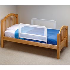 a small wooden bed with a blue sheet on it's bottom and side rails