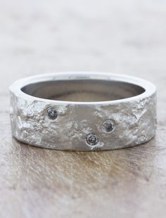 a silver ring with three diamonds on it