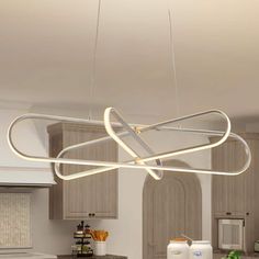 a kitchen with a large light fixture hanging from it's ceiling above the counter