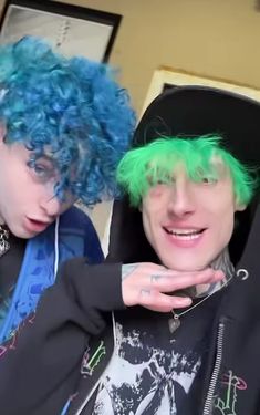 two people with blue and green hair posing for the camera