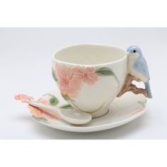 a cup and saucer with two birds on it