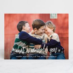 a christmas card with three children hugging each other