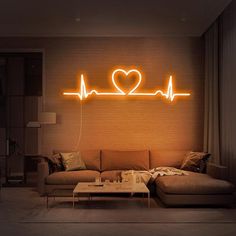 a living room with a couch, coffee table and neon sign that says love on the wall