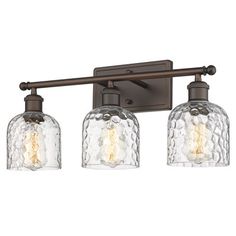 three light bathroom fixture with glass shades on the bottom and an old - fashioned bronze finish