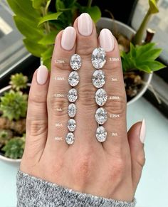 a woman's hand with three different sized diamonds on it, and the other two are