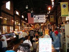 an indoor market with lots of people shopping