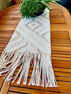 a potted plant sitting on top of a wooden table next to a white rug