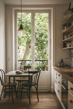 a kitchen with a table and chairs next to an open door that leads to the outside